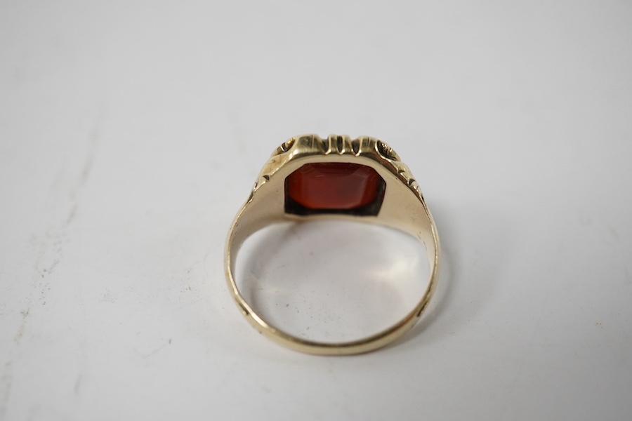 A carved yellow metal and carnelian set signet ring, size I/J, gross weight 5.1 grams. Condition - fair